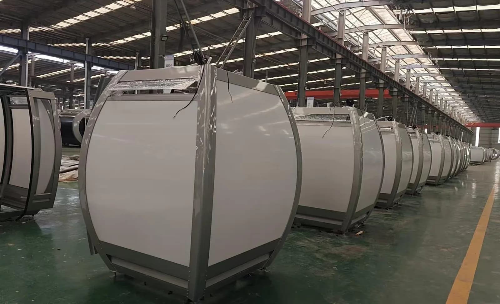Rows of completed observation-wheel cabins inside Juma's production facility